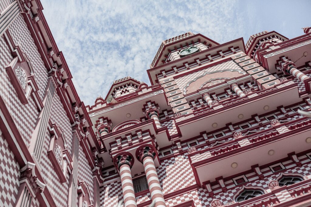An image of a Stunning mosque with towering minarets and red and white stripes, located in the busy Pettah neighbourhood of Colombo, Sri Lanka.