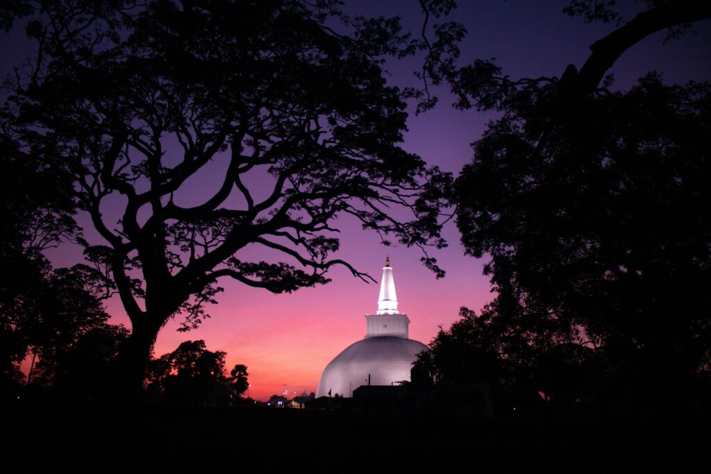 This stupa is the Ruwanweli Maha Seya in Anuradhapura, Sri Lanka. The stupa has a distinctive pear-shaped dome and is one of the largest stupas in Sri Lanka. Anuradhapura is a popular tourist destination with many ancient Buddhist sites and one of the best family tour destinations in Sri Lanka.